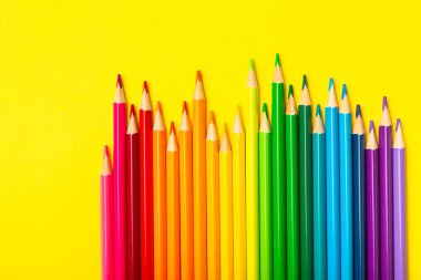 Renkli arka planda renkli kalemler. Boyama için ekipman. Yaratıcılık için kırtasiye malzemesi. Okula dönüyorum. Flatlay. Çocukların Yaratıcılığı ve Eğitimi. Rainbow.Mesaj için yer var. Boşluğu kopyala.