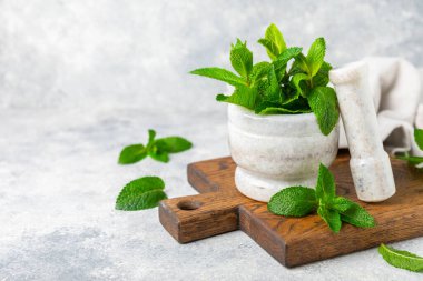 Ahşap zemin üzerinde havan ve kabuk ile taze nane. Melissa gider. Şifalı bitkiler, ilaç için havanda yeşil nane yaprakları. Mesaj için alan. Boşluğu kopyala.