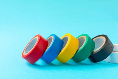 Parlak renkli arka plandaki bant yalıtılıyor. Farklı renkte izolasyon bantları. Yalıtım bandı. İnşaat aletleri. Elektrikçi aletleri. Bir parça koli bandı. Metin için boşluk. Boşluğu kopyala.