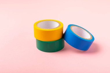 Parlak renkli arka plandaki bant yalıtılıyor. Farklı renkte izolasyon bantları. Yalıtım bandı. İnşaat aletleri. Elektrikçi aletleri. Bir parça koli bandı. Metin için boşluk. Boşluğu kopyala.