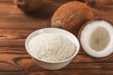 Tahta arka planda taze hindistan cevizi ve dilimler var. Hindistan cevizi gevreği. Vejetaryen. Tropik fındık, meyve. Mesaj için yer. Boşluğu kopyala.