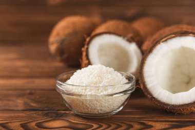 Tahta arka planda taze hindistan cevizi ve dilimler var. Hindistan cevizi gevreği. Vejetaryen. Tropik fındık, meyve. Mesaj için yer. Boşluğu kopyala.