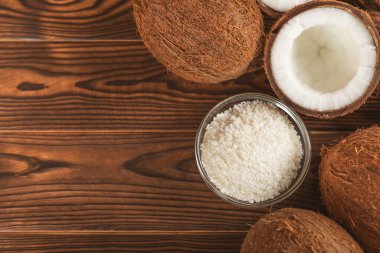 Tahta arka planda taze hindistan cevizi ve dilimler var. Hindistan cevizi gevreği. Vejetaryen. Tropik fındık, meyve. Mesaj için yer. Boşluğu kopyala.