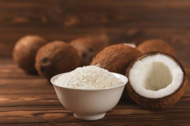 Tahta arka planda taze hindistan cevizi ve dilimler var. Hindistan cevizi gevreği. Vejetaryen. Tropik fındık, meyve. Mesaj için yer. Boşluğu kopyala.