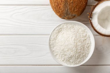 Tahta arka planda taze hindistan cevizi ve dilimler var. Hindistan cevizi gevreği. Vejetaryen. Tropik fındık, meyve. Mesaj için yer. Boşluğu kopyala.