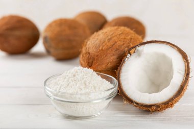 Tahta arka planda taze hindistan cevizi ve dilimler var. Hindistan cevizi gevreği. Vejetaryen. Tropik fındık, meyve. Mesaj için yer. Boşluğu kopyala.