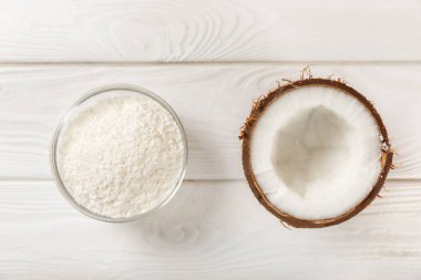 Tahta arka planda taze hindistan cevizi ve dilimler var. Hindistan cevizi gevreği. Vejetaryen. Tropik fındık, meyve. Mesaj için yer. Boşluğu kopyala.