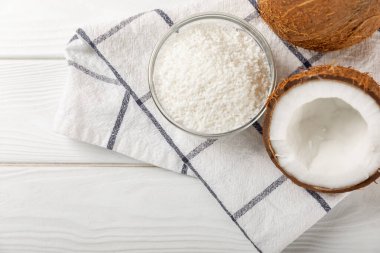 Tahta arka planda taze hindistan cevizi ve dilimler var. Hindistan cevizi gevreği. Vejetaryen. Tropik fındık, meyve. Mesaj için yer. Boşluğu kopyala.