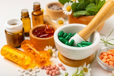 Ahşap zemin üzerinde alternatif ilaç bitkisel kapsül organik ilaç. Bitki ve tablet çeşitleri, vitaminler ve diyet takviyeleri. Sağlıklı yaşam için tıbbi ve şifalı bitkiler.