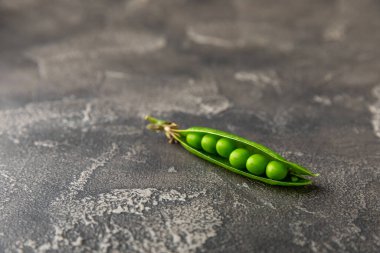 Ahşap zemin üzerinde yeşil bezelyeler olan taze bezelye kabukları. Tatlı yeşil bezelyeler. Yeşil bezelye fasulyesi sebzesi. Vejetaryen. Sağlıklı sebze. Boşluğu kopyala