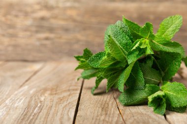 Naneli. Ahşap arka planda taze organik nane yaprakları. Nane yaprakları. Nane şekeri. Yakın plan. Mesaj için yer var. Boşluğu kopyala.