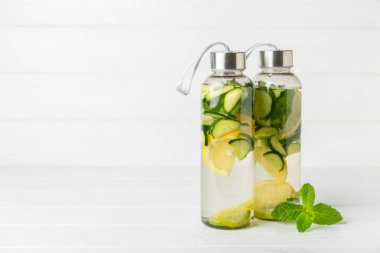 Salatalık suyu, limon, nane ve ahşap bir masada. İçme bardağında dilimlenmiş salatalık ile karıştırılmış su. Tonik ferahlatıcı bir içecek. Salatalık limonata. Doğal soğutma içeceği. Boşluğu kopyala.