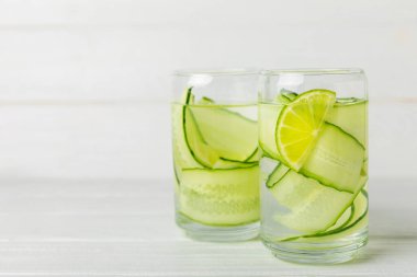 Salatalık suyu, limon, nane ve ahşap bir masada. İçme bardağında dilimlenmiş salatalık ile karıştırılmış su. Tonik ferahlatıcı bir içecek. Salatalık limonata. Doğal soğutma içeceği. Boşluğu kopyala.