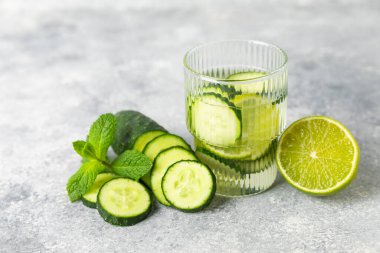 Salatalık suyu, limon, nane ve ahşap bir masada. İçme bardağında dilimlenmiş salatalık ile karıştırılmış su. Tonik ferahlatıcı bir içecek. Salatalık limonata. Doğal soğutma içeceği. Boşluğu kopyala.