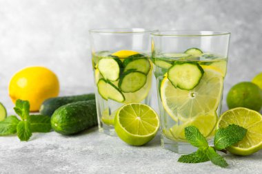 Salatalık suyu, limon, nane ve ahşap bir masada. İçme bardağında dilimlenmiş salatalık ile karıştırılmış su. Tonik ferahlatıcı bir içecek. Salatalık limonata. Doğal soğutma içeceği. Boşluğu kopyala.