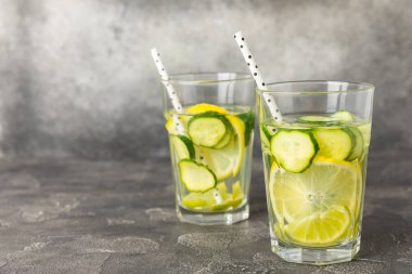 Salatalık suyu, limon, nane ve ahşap bir masada. İçme bardağında dilimlenmiş salatalık ile karıştırılmış su. Tonik ferahlatıcı bir içecek. Salatalık limonata. Doğal soğutma içeceği. Boşluğu kopyala.