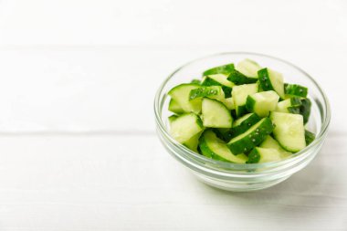 Ahşap arka planda salatalık. Arka planda bir parça salatalık. Taze organik yeşil salatalık turşusu. Vejetaryen. Salata malzemesi. Çiftlik sebzeleri. Sebzeleri bıçakla kes. Mesaj için yer var. Boşluğu kopyala