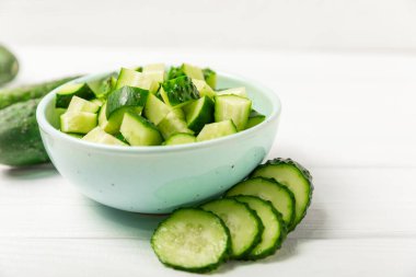 Ahşap arka planda salatalık. Arka planda bir parça salatalık. Taze organik yeşil salatalık turşusu. Vejetaryen. Salata malzemesi. Çiftlik sebzeleri. Sebzeleri bıçakla kes. Mesaj için yer var. Boşluğu kopyala