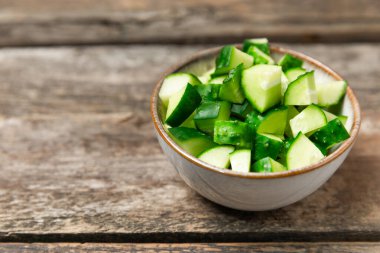 Ahşap arka planda salatalık. Arka planda bir parça salatalık. Taze organik yeşil salatalık turşusu. Vejetaryen. Salata malzemesi. Çiftlik sebzeleri. Sebzeleri bıçakla kes. Mesaj için yer var. Boşluğu kopyala