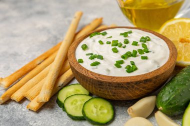 Ahşap bir masada salatalık kremalı tzatziki sosu. Tatar sosu. Geleneksel lezzetli aperatif. Yoğurt sosu. Tzatziki, salatalık, sarımsak, dereotu, limon, nane. Salata sosu. Kopya alanı.