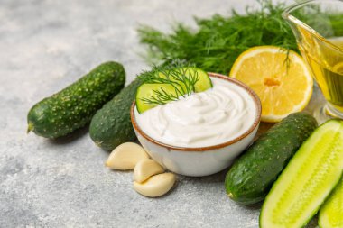 Ahşap bir masada salatalık kremalı tzatziki sosu. Tatar sosu. Geleneksel lezzetli aperatif. Yoğurt sosu. Tzatziki, salatalık, sarımsak, dereotu, limon, nane. Salata sosu. Kopya alanı.