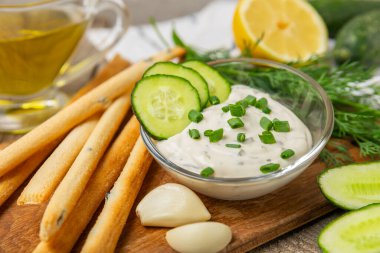 Ahşap bir masada salatalık kremalı tzatziki sosu. Tatar sosu. Geleneksel lezzetli aperatif. Yoğurt sosu. Tzatziki, salatalık, sarımsak, dereotu, limon, nane. Salata sosu. Kopya alanı.