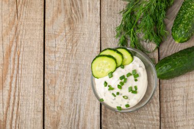 Ahşap bir masada salatalık kremalı tzatziki sosu. Tatar sosu. Geleneksel lezzetli aperatif. Yoğurt sosu. Tzatziki, salatalık, sarımsak, dereotu, limon, nane. Salata sosu. Kopya alanı.