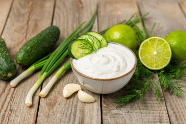 Ahşap bir masada salatalık kremalı tzatziki sosu. Tatar sosu. Geleneksel lezzetli aperatif. Yoğurt sosu. Tzatziki, salatalık, sarımsak, dereotu, limon, nane. Salata sosu. Kopya alanı.
