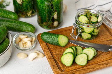 Ahşap bir arka planda kavanozda taze tuzlanmış ev yapımı salatalıklar. Dereotlu, sarımsaklı ve biberli salatalık turşusu. Konserve salatalık, salatalık ve penis. Ev yapımı koruma..