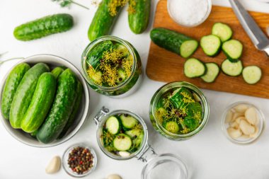 Ahşap bir arka planda kavanozda taze tuzlanmış ev yapımı salatalıklar. Dereotlu, sarımsaklı ve biberli salatalık turşusu. Konserve salatalık, salatalık ve penis. Ev yapımı koruma..