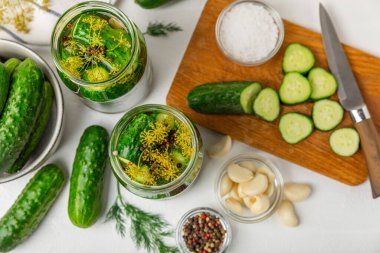 Ahşap bir arka planda kavanozda taze tuzlanmış ev yapımı salatalıklar. Dereotlu, sarımsaklı ve biberli salatalık turşusu. Konserve salatalık, salatalık ve penis. Ev yapımı koruma..