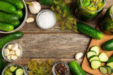 Ahşap bir arka planda kavanozda taze tuzlanmış ev yapımı salatalıklar. Dereotlu, sarımsaklı ve biberli salatalık turşusu. Konserve salatalık, salatalık ve penis. Ev yapımı koruma..