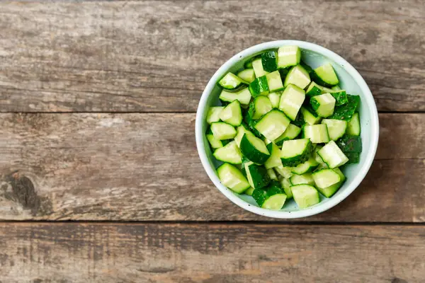Ahşap arka planda salatalık. Arka planda bir parça salatalık. Taze organik yeşil salatalık turşusu. Vejetaryen. Salata malzemesi. Çiftlik sebzeleri. Sebzeleri bıçakla kes. Mesaj için yer var. Boşluğu kopyala