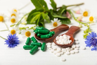 Ahşap zemin üzerinde alternatif ilaç bitkisel kapsül organik ilaç. Bitki ve tablet çeşitleri, vitaminler ve diyet takviyeleri. Sağlıklı yaşam için tıbbi ve şifalı bitkiler.