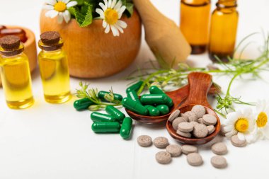 Ahşap zemin üzerinde alternatif ilaç bitkisel kapsül organik ilaç. Bitki ve tablet çeşitleri, vitaminler ve diyet takviyeleri. Sağlıklı yaşam için tıbbi ve şifalı bitkiler.