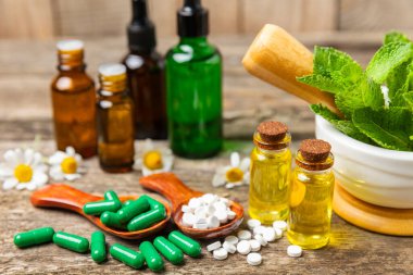 Ahşap zemin üzerinde alternatif ilaç bitkisel kapsül organik ilaç. Bitki ve tablet çeşitleri, vitaminler ve diyet takviyeleri. Sağlıklı yaşam için tıbbi ve şifalı bitkiler.