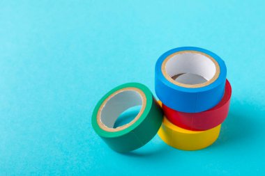 Parlak renkli arka plandaki bant yalıtılıyor. Farklı renkte izolasyon bantları. Yalıtım bandı. İnşaat aletleri. Elektrikçi aletleri. Bir parça koli bandı. Metin için boşluk. Boşluğu kopyala.