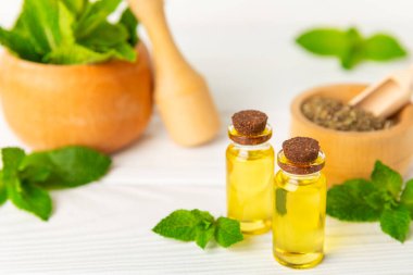 Ahşap bir arka planda esaslı bir nane şekeri. Naneli esaslı yağ ve taze nane yaprakları. Bir şişe aromaterapi yağı. Nane özütü. Doğal kozmetik konsepti, spa bakımı. Boşluğu kopyala