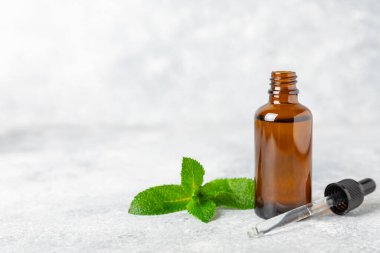 Ahşap bir arka planda esaslı bir nane şekeri. Naneli esaslı yağ ve taze nane yaprakları. Bir şişe aromaterapi yağı. Nane özütü. Doğal kozmetik konsepti, spa bakımı. Boşluğu kopyala