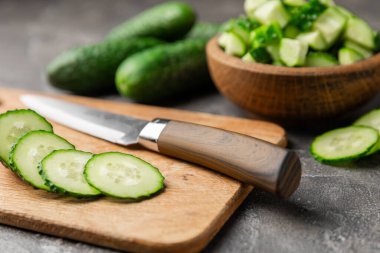 Ahşap arka planda salatalık. Arka planda bir parça salatalık. Taze organik yeşil salatalık turşusu. Vejetaryen. Salata malzemesi. Çiftlik sebzeleri. Sebzeleri bıçakla kes. Mesaj için yer var. Boşluğu kopyala
