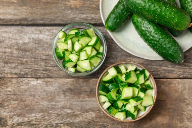 Ahşap arka planda salatalık. Arka planda bir parça salatalık. Taze organik yeşil salatalık turşusu. Vejetaryen. Salata malzemesi. Çiftlik sebzeleri. Sebzeleri bıçakla kes. Mesaj için yer var. Boşluğu kopyala