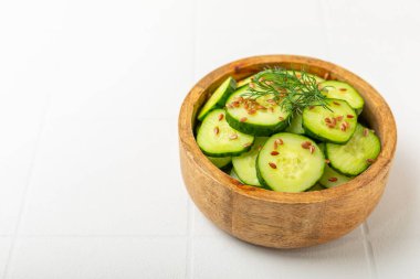 Ahşap bir arka planda salatalık. Taze sebzeli, salatalıklı, domatesli, tatlı biberli ve salatalı ev yapımı salata. Vejetaryen bahar salatası.