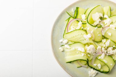 Ahşap bir arka planda salatalık. Taze sebzeli, salatalıklı, domatesli, tatlı biberli ve salatalı ev yapımı salata. Vejetaryen bahar salatası.