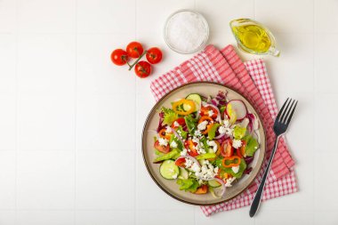 Ahşap bir arka planda salatalık. Taze sebzeli, salatalıklı, domatesli, tatlı biberli ve salatalı ev yapımı salata. Vejetaryen bahar salatası.