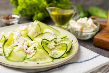 Ahşap bir arka planda salatalık. Taze sebzeli, salatalıklı, domatesli, tatlı biberli ve salatalı ev yapımı salata. Vejetaryen bahar salatası.