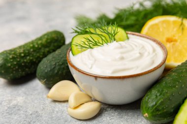 Ahşap bir masada salatalık kremalı tzatziki sosu. Tatar sosu. Geleneksel lezzetli aperatif. Yoğurt sosu. Tzatziki, salatalık, sarımsak, dereotu, limon, nane. Salata sosu. Kopya alanı.