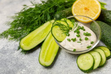 Ahşap bir masada salatalık kremalı tzatziki sosu. Tatar sosu. Geleneksel lezzetli aperatif. Yoğurt sosu. Tzatziki, salatalık, sarımsak, dereotu, limon, nane. Salata sosu. Kopya alanı.