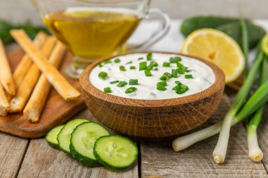 Ahşap bir masada salatalık kremalı tzatziki sosu. Tatar sosu. Geleneksel lezzetli aperatif. Yoğurt sosu. Tzatziki, salatalık, sarımsak, dereotu, limon, nane. Salata sosu. Kopya alanı.
