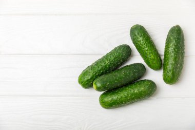 Ahşap arka planda salatalık. Arka planda bir parça salatalık. Taze organik yeşil salatalık turşusu. Vejetaryen. Salata malzemesi. Çiftlik sebzeleri. Sebzeleri bıçakla kes. Mesaj için yer var. Boşluğu kopyala