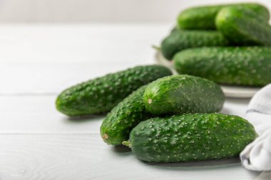 Ahşap arka planda salatalık. Arka planda bir parça salatalık. Taze organik yeşil salatalık turşusu. Vejetaryen. Salata malzemesi. Çiftlik sebzeleri. Sebzeleri bıçakla kes. Mesaj için yer var. Boşluğu kopyala